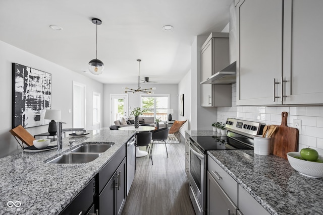 1935 Cornell Ave, Indianapolis, IN 46202 - kitchen with stainless steel appliances, a chandelier, decorative backsplash, light stone counters, and dark wood-style flooring