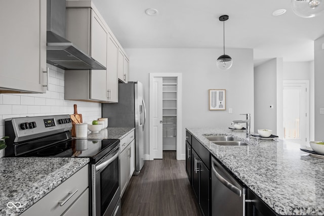1935 Cornell Ave, Indianapolis, IN 46202 - kitchen with appliances with stainless steel finishes, wall chimney range hood, tasteful backsplash, dark wood-type flooring, and pendant lighting