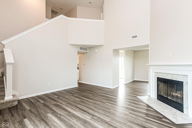 990 Constellation Way, Franklin, IN 46131 - unfurnished living room with a high ceiling, wood finished floors, stairway, and a tiled fireplace