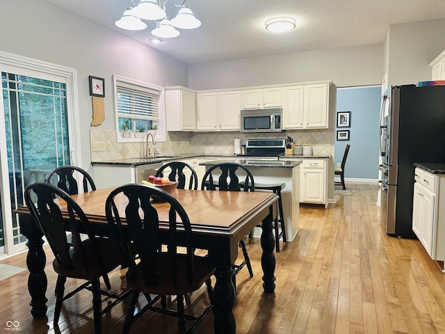 9975 Woodstock Way, Fishers, IN 46037 - dining area with light wood finished floors and a chandelier