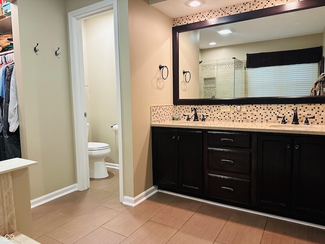 9975 Woodstock Way, Fishers, IN 46037 - bathroom featuring decorative backsplash, double vanity, wood finished floors, and tiled shower