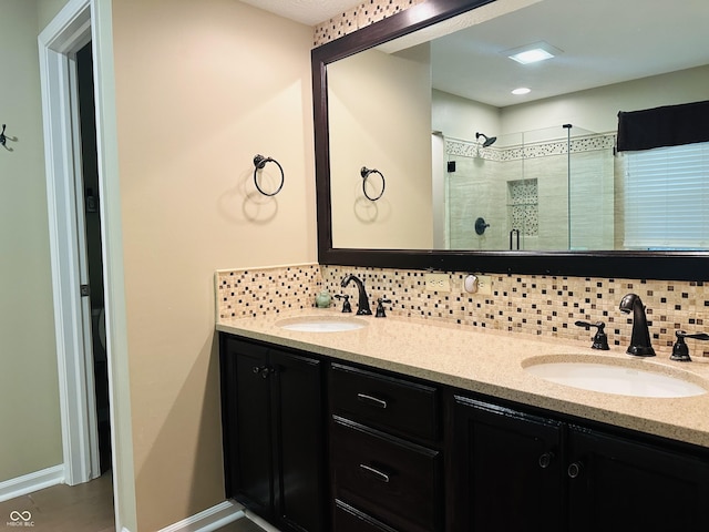 9975 Woodstock Way, Fishers, IN 46037 - full bathroom featuring decorative backsplash, double vanity, and a stall shower