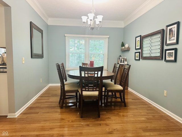 9975 Woodstock Way, Fishers, IN 46037 - dining area with a chandelier, ornamental molding, and light wood-style flooring