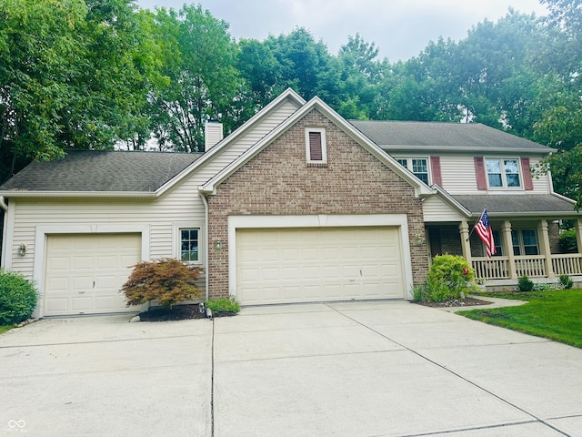 9975 Woodstock Way, Fishers, IN 46037 - traditional-style home featuring a garage, concrete driveway, brick siding, a chimney, and a porch