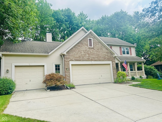 9975 Woodstock Way, Fishers, IN 46037 - traditional home with a garage, a porch, concrete driveway, a chimney, and brick siding