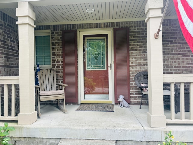 9975 Woodstock Way, Fishers, IN 46037 - doorway to property featuring a porch and brick siding