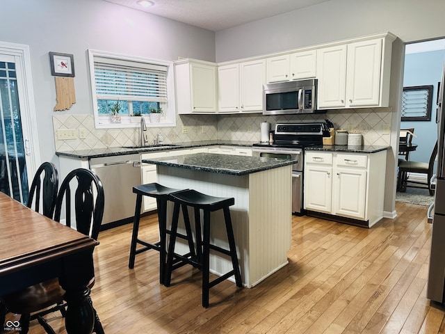 9975 Woodstock Way, Fishers, IN 46037 - kitchen featuring stainless steel appliances, a center island, light wood-type flooring, and white cabinetry