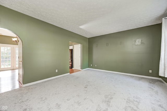 1143 Kinross Dr, Avon, IN 46123 - unfurnished room featuring carpet, a chandelier, a textured ceiling, and arched walkways