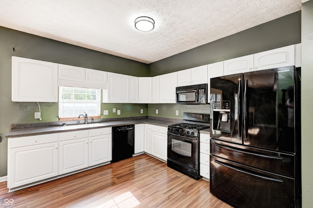 1143 Kinross Dr, Avon, IN 46123 - kitchen with black appliances, a textured ceiling, white cabinetry, and light wood-style floors