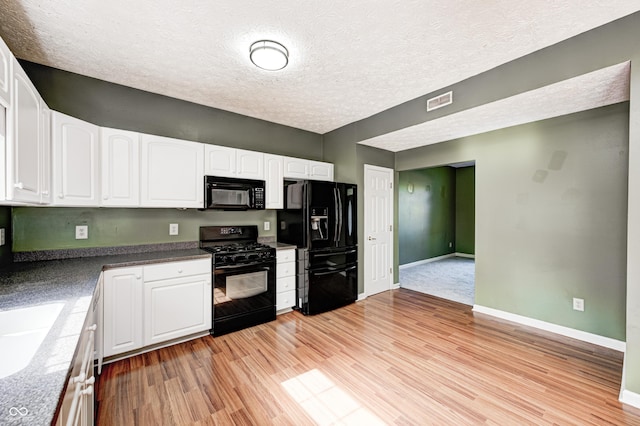 1143 Kinross Dr, Avon, IN 46123 - kitchen with black appliances, white cabinetry, light wood-style flooring, a textured ceiling, and dark countertops