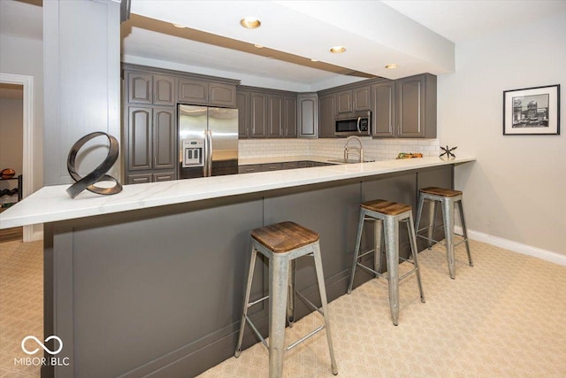 13023 Water Ridge Dr, Mccordsville, IN 46055 - kitchen featuring stainless steel appliances, light carpet, a peninsula, a breakfast bar area, and recessed lighting
