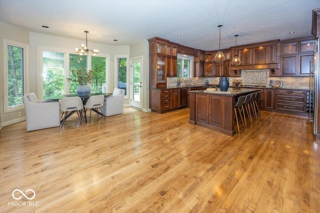 13023 Water Ridge Dr, Mccordsville, IN 46055 - kitchen featuring a chandelier, light wood finished floors, dishwashing machine, a kitchen island, and decorative backsplash