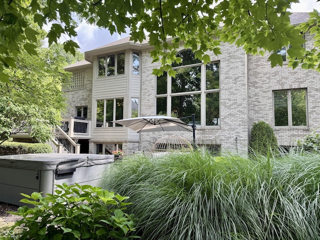 13023 Water Ridge Dr, Mccordsville, IN 46055 - view of side of home featuring a hot tub, brick siding, and a wooden deck
