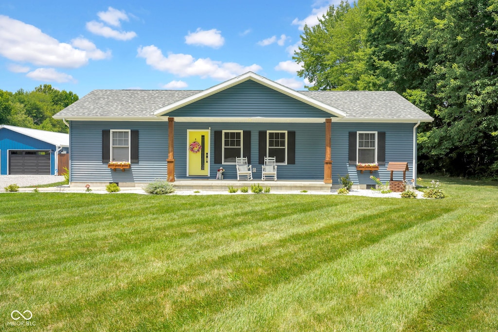 6080 W County Road 300 N, North Vernon, IN 47265 - view of front of house featuring a shingled roof, a porch, a front yard, and a garage