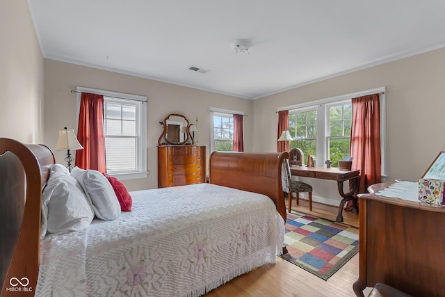 613 5th St, Columbus, IN 47201 - bedroom with multiple windows, light wood-style floors, and crown molding
