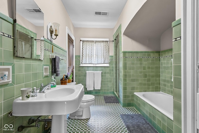613 5th St, Columbus, IN 47201 - full bathroom featuring tile walls, tiled shower, and tiled tub