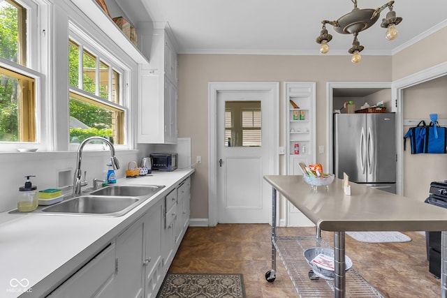 613 5th St, Columbus, IN 47201 - kitchen with freestanding refrigerator, crown molding, light countertops, stone finish flooring, and white cabinetry