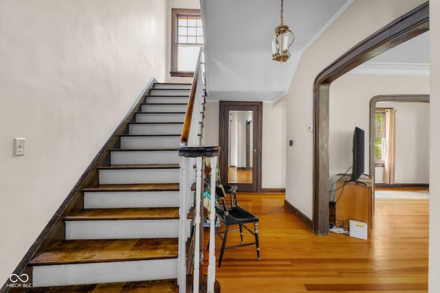 613 5th St, Columbus, IN 47201 - stairs featuring crown molding, wood finished floors, and arched walkways