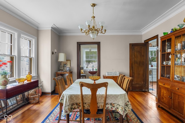 613 5th St, Columbus, IN 47201 - dining area featuring a chandelier, healthy amount of natural light, light wood-style floors, and ornamental molding