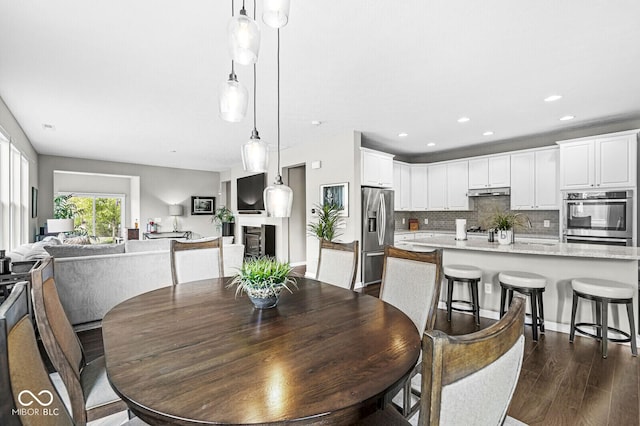 10868 Matherly Way, Noblesville, IN 46060 - dining room with dark wood-type flooring, a glass covered fireplace, and recessed lighting
