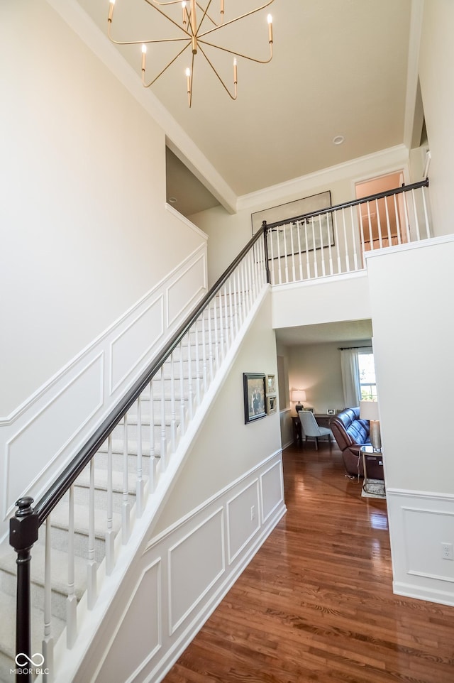 6802 Chorleywood Cir, Indianapolis, IN 46259 - stairway with a decorative wall, ornamental molding, a chandelier, a wainscoted wall, and wood finished floors