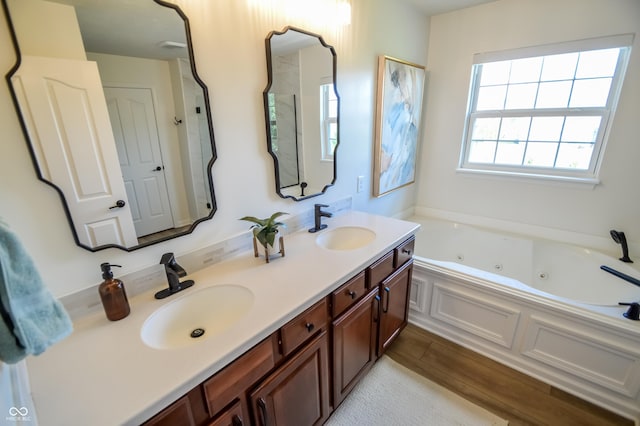6802 Chorleywood Cir, Indianapolis, IN 46259 - bathroom with double vanity, a jetted tub, and wood finished floors