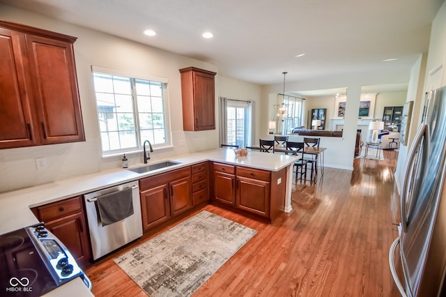 6802 Chorleywood Cir, Indianapolis, IN 46259 - kitchen with appliances with stainless steel finishes, a peninsula, light wood-type flooring, light countertops, and recessed lighting