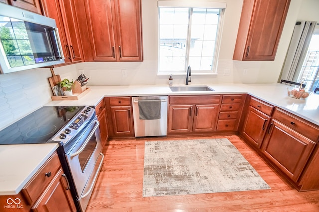 6802 Chorleywood Cir, Indianapolis, IN 46259 - kitchen featuring appliances with stainless steel finishes, light wood-type flooring, light countertops, and brown cabinetry