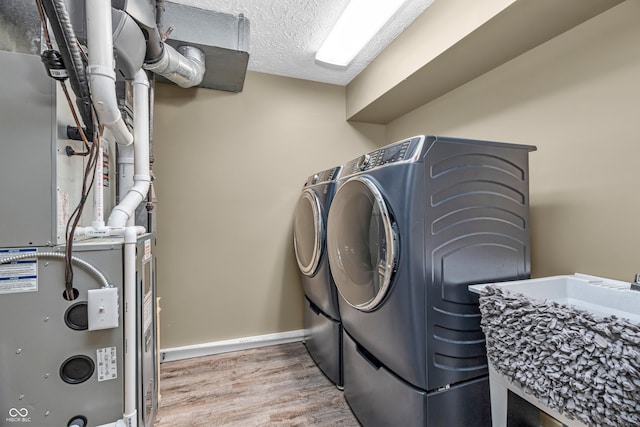 5052 Sherwood Ct, Pittsboro, IN 46167 - laundry room with separate washer and dryer, heating unit, light wood-type flooring, and a textured ceiling
