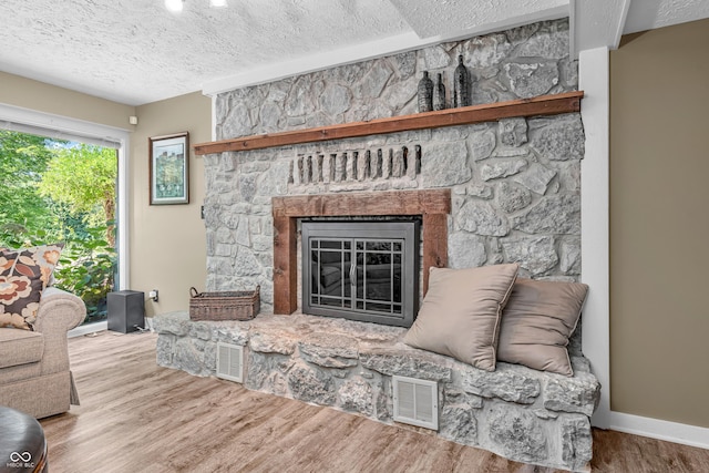 5052 Sherwood Ct, Pittsboro, IN 46167 - living area with a textured ceiling, wood finished floors, and a stone fireplace