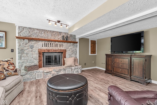 5052 Sherwood Ct, Pittsboro, IN 46167 - living area featuring wood finished floors, a textured ceiling, and a stone fireplace