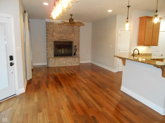 7653 W Old Colony Dr, New Palestine, IN 46163 - unfurnished living room featuring ceiling fan, dark wood-type flooring, a fireplace, and recessed lighting
