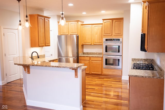 7653 W Old Colony Dr, New Palestine, IN 46163 - kitchen with appliances with stainless steel finishes, a peninsula, recessed lighting, light wood-style floors, and a kitchen bar