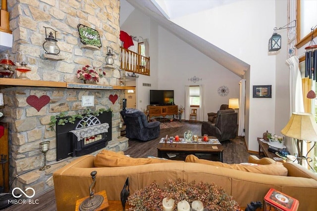 8546 N Chickadee Dr, Morgantown, IN 46160 - living room featuring a towering ceiling, wood finished floors, a stone fireplace, and healthy amount of natural light