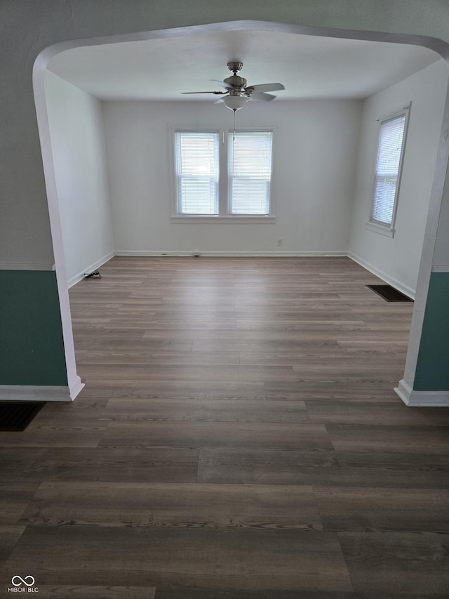 2311 Gilmore St, Columbus, IN 47201 - unfurnished room featuring arched walkways, healthy amount of natural light, wood finished floors, and ceiling fan