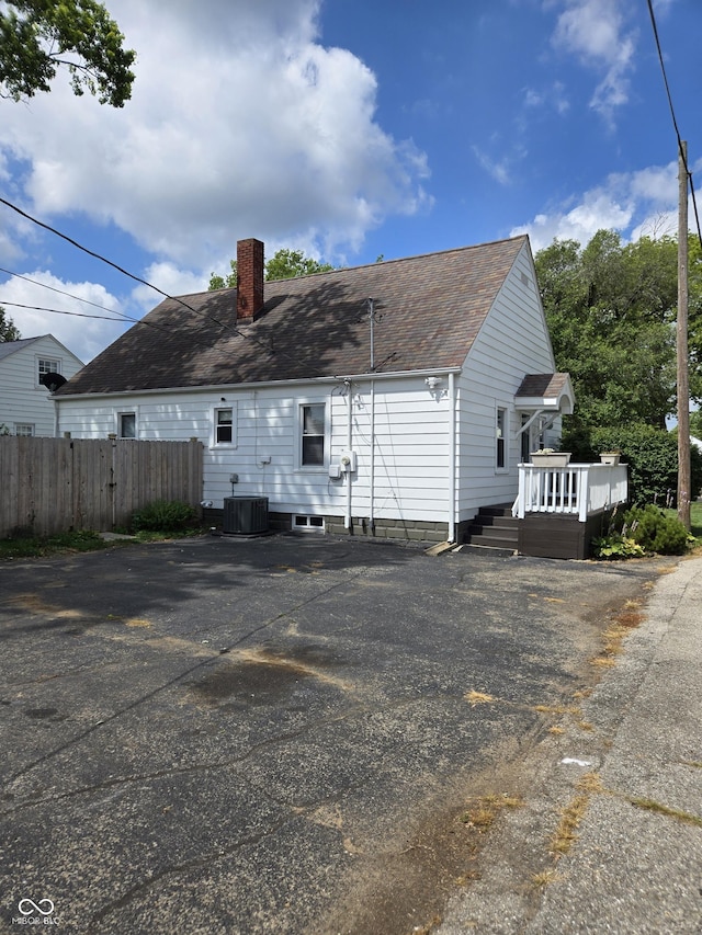2311 Gilmore St, Columbus, IN 47201 - view of side of home featuring a chimney, a wooden deck, and a shingled roof