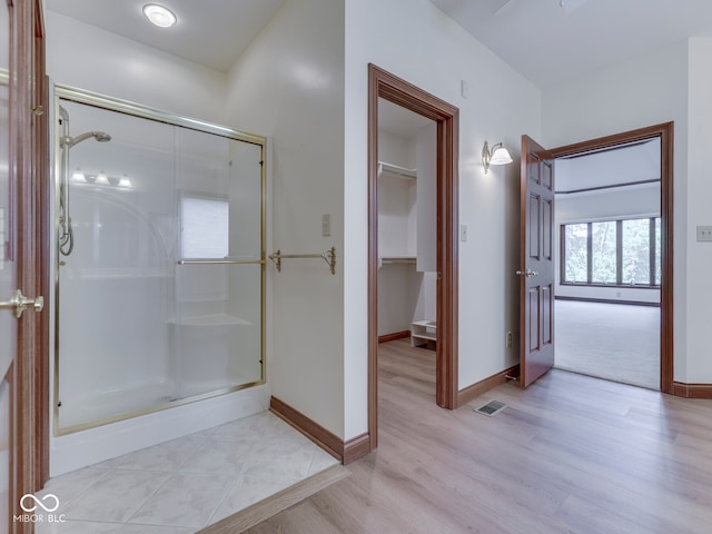 2025 Caledonian Ct, Greenwood, IN 46143 - full bath featuring a stall shower, a walk in closet, and wood finished floors
