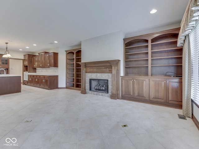 2025 Caledonian Ct, Greenwood, IN 46143 - unfurnished living room featuring a tile fireplace, light tile patterned floors, and recessed lighting