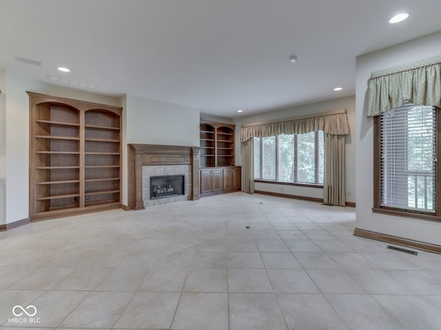 2025 Caledonian Ct, Greenwood, IN 46143 - unfurnished living room with a tile fireplace, light tile patterned floors, recessed lighting, and built in features