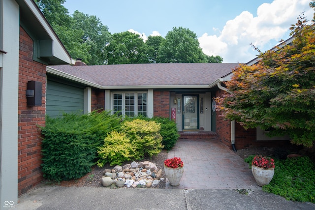 8841 Rocky Ridge Rd, Indianapolis, IN 46217 - property entrance featuring roof with shingles and brick siding