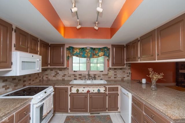 8841 Rocky Ridge Rd, Indianapolis, IN 46217 - kitchen with white appliances, decorative backsplash, light tile patterned flooring, a peninsula, and rail lighting
