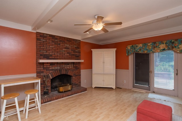 8841 Rocky Ridge Rd, Indianapolis, IN 46217 - living room featuring a ceiling fan, light wood finished floors, wainscoting, and a fireplace