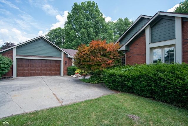 8841 Rocky Ridge Rd, Indianapolis, IN 46217 - view of front of house featuring brick siding, driveway, a garage, and a front yard