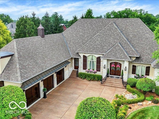 3808 Claybrook Ct, Bargersville, IN 46106 - french country home featuring an attached garage, stone siding, concrete driveway, and french doors