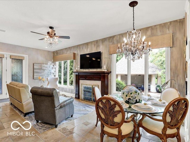 3808 Claybrook Ct, Bargersville, IN 46106 - dining room with stone tile flooring, a ceiling fan, a chandelier, a fireplace, and plenty of natural light