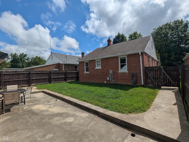 1630 Lawton Ave, Columbus, IN 47201 - rear view of property featuring brick siding, a patio, a chimney, a fenced backyard, and a shingled roof