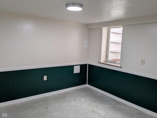 1630 Lawton Ave, Columbus, IN 47201 - unfurnished room featuring concrete floors and a wainscoted wall