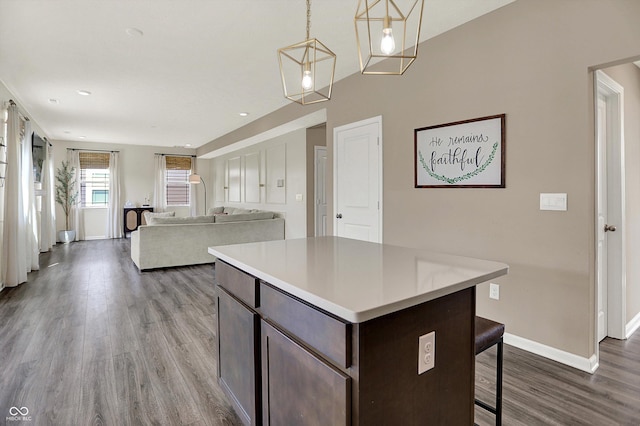 1715 Beyers St, Fortville, IN 46040 - kitchen with dark brown cabinetry, wood finished floors, a breakfast bar, light countertops, and a center island