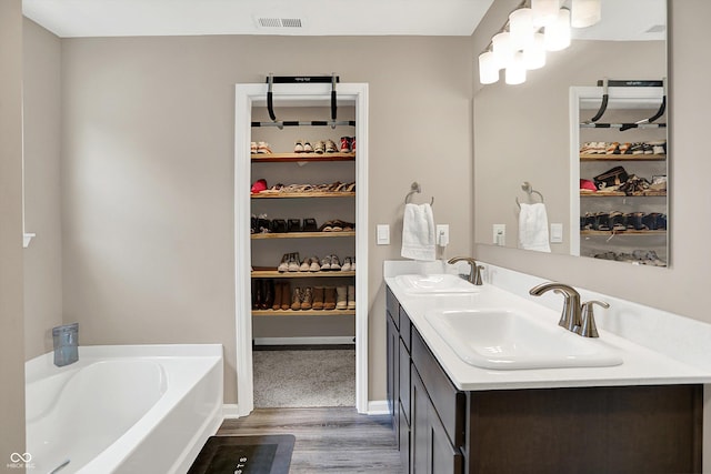 1715 Beyers St, Fortville, IN 46040 - full bathroom with wood finished floors, double vanity, a bath, and a spacious closet
