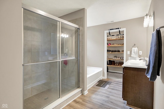 1715 Beyers St, Fortville, IN 46040 - bathroom featuring vanity, a shower stall, a bath, wood finished floors, and a walk in closet